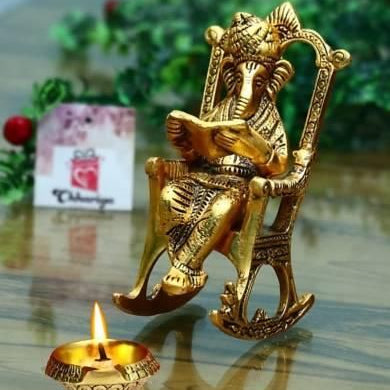 Golden Lord Ganesha Statue Sitting On A Rocking Chair And Reading Ramayan Showpiece